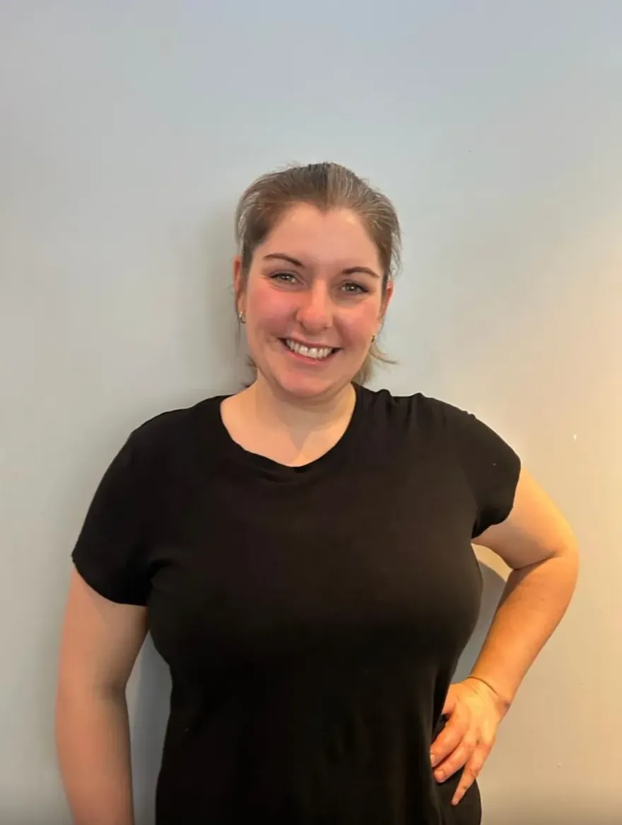 Sarah Dennis, Registered Massage Therapist, smiling in a treatment room